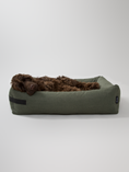 Afbeelding geladen in Galerij-viewer, Green eco-friendly dog bed from Hygge collection with a comfortable design featuring a brown dog lying down.
